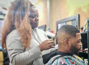 Barber Yohnee Miller with client cutting hair