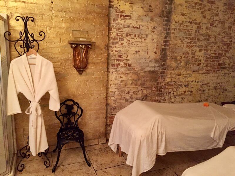 spa room with robe hanging and massage table nearby