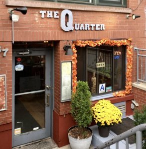 Front door of The Quarter, with logo and flowers