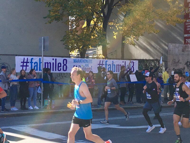 marathon runners with crowd cheering as they pass by