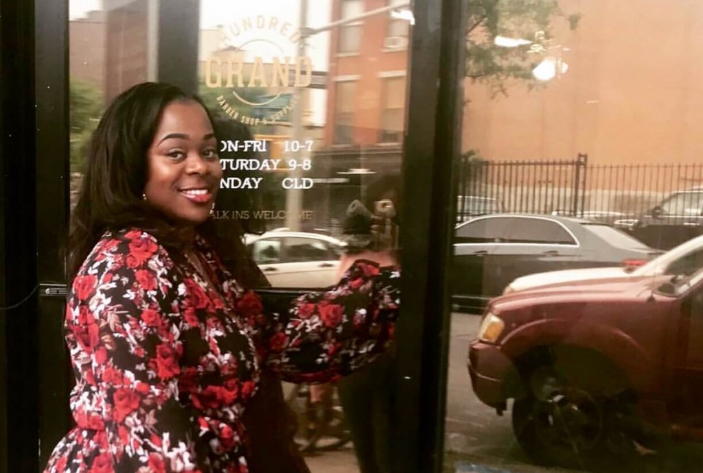 Yohnee Miller in front of Hundred Grand Barbershop