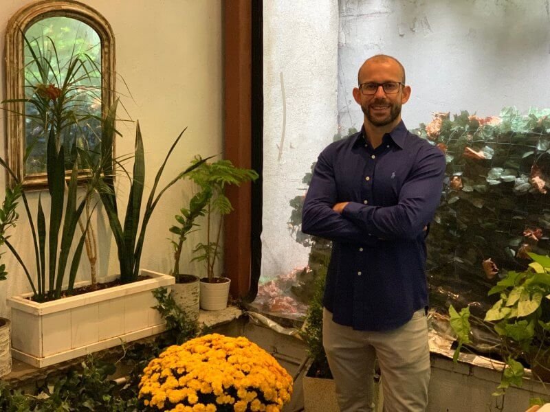 The Quarter Manager Fatih Yilmaz standing in garden area of the restaurant