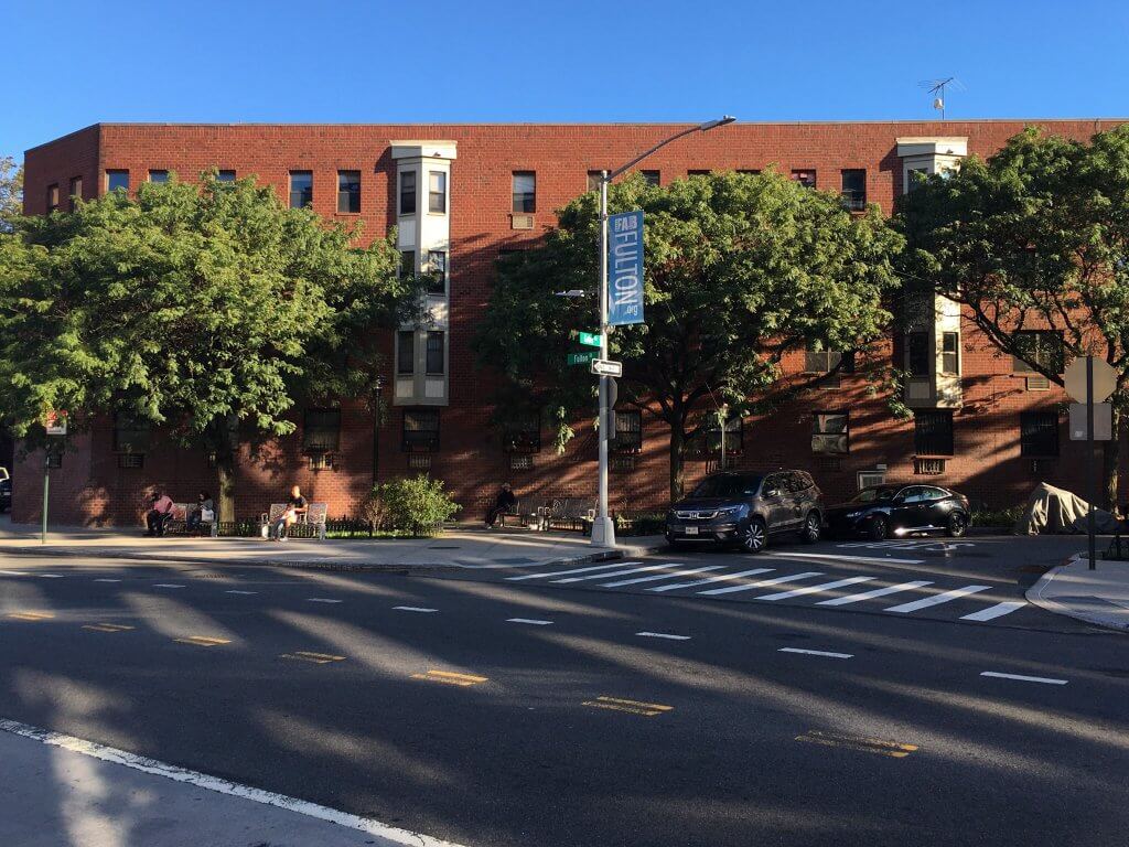 block of apartments with FAB FULTON banner in foreground on Fulton Street