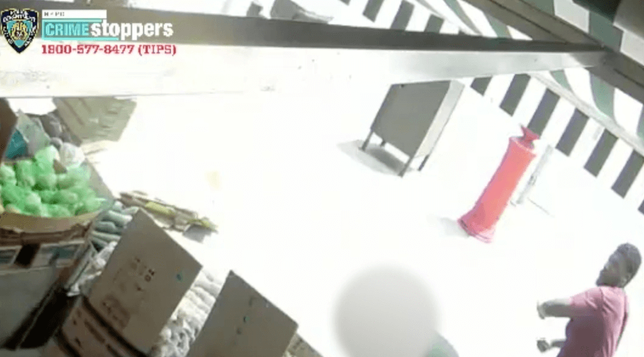 Crime Stoppers still from video showing assailant ready to attack grocery worker on sidewalk