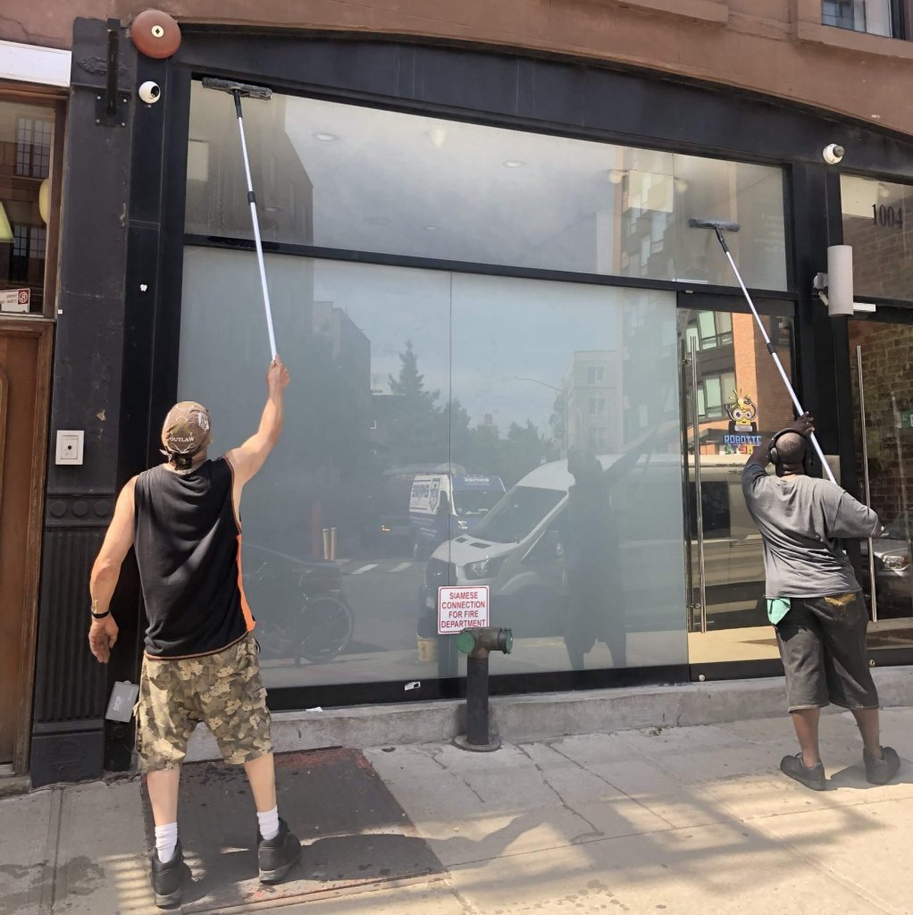 Window washers working on a Fulton Street business storefront